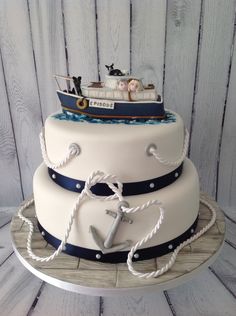 a three tiered cake with an anchor and boat on top