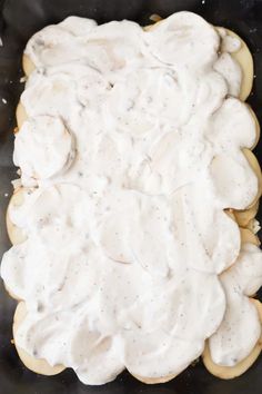 a pan filled with cookies covered in white icing