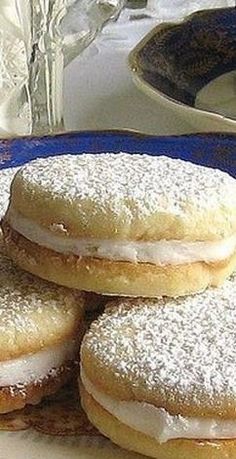 powdered sugar covered donuts stacked on top of each other in a blue plate