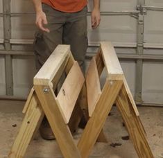 a man standing next to two wooden step stools in front of a garage door