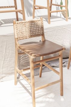 two wooden chairs sitting next to each other on top of a white sheet covered ground