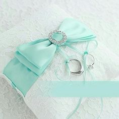 a ring bearer and wedding garter on top of a lace covered pillow with ribbon