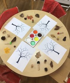 a wooden table topped with paper cutouts and paint