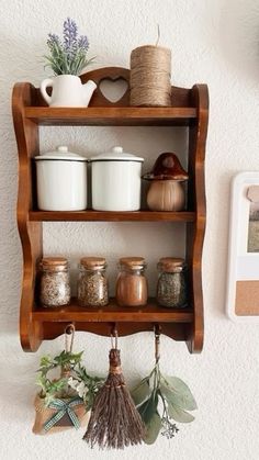 a shelf that has some jars on top of it and other items hanging from the wall