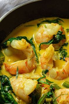 some shrimp and spinach in a yellow sauce