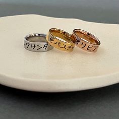 This is a personalized dark engraved Japanese name ring in stainless steel. Stainless steel jewelry (original color without plating) is strong and almost never tarnish or corrode. Please see below for more details on sample rings.  Original: Alexander in Japanese font #4 Gold: Sebastian in Japanese font #5 Rose: Olivia in Japanese font #1 Please check the font options in the pictures. Font #6 doesn't work for most Kanji characters.  The ring is approximately 6 mm wide. All orders come gift-wrapp Symbolic Stainless Steel Engraved Ring As Gift, Symbolic Stainless Steel Engraved Ring For Gift, Silver Laser Engraved Rings As Gift, Japanese Rings, Japanese Ring, Japanese Font, Kanji Characters, Japan Gifts, Name Rings