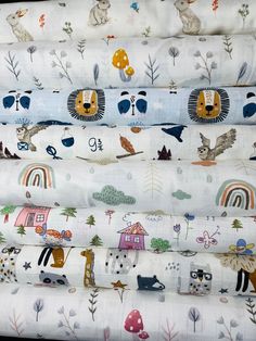 the fabric is all different colors and animals on white background, including one with blue eyes