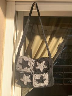 a crocheted bag hanging from a window sill