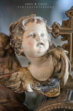 a statue of an angel on top of a clock with the words,'antique interiors '