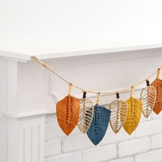 a string with leaves hanging from it next to a fireplace