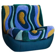 a blue and yellow chair with a pillow on it's seat cushion that is shaped like an abstract wave