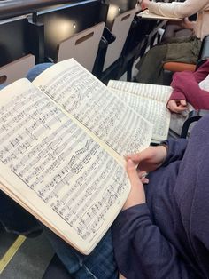 an open book with sheet music on it is being held in someone's lap