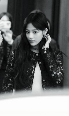 black and white photograph of a woman talking on her cell phone in front of a mirror