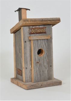 a birdhouse made out of wood with a roof and window on the top that says outhouse