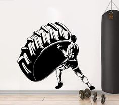 a black and white wall decal with a man carrying a large tire on it