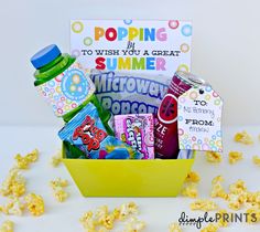 a yellow basket filled with popcorn and drinks next to a sign that says poppin's summer gift prints