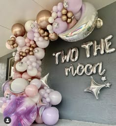 there is a balloon arch that says, i'm the moon and balloons all around it