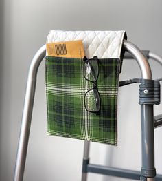 a pair of glasses sitting on top of a green and white checkered cloth bag