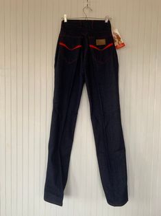 "Rare NWT Vintage Early 80s High Waisted Dark Denim Blue Jeans, by Hush Puppies. New condition and unworn with original tags. Super high rise waist. Front & back pleated down center of leg. Dark denim with red stitching, embroidered back pockets with basset hound logo. Amazing Original condition with original store tags! Brand - Hush Puppies Condition - Original. Deadstock from the 80s, New with original tags 100% Cotton Made in Taiwan Machine Washable Vintage Size - 8 Size - 26\" waist Best Vintage Stretch Denim Blue Jeans, Retro Stretch Flare Jeans, Retro Fitted Full-length Jeans, Retro Full-length Fitted Jeans, Retro Fitted Full Length Jeans, Vintage Stretch Jeans In Medium Wash, Retro Fitted Medium Wash Jeans, Medium Wash Retro Fitted Jeans, Red Retro Denim Bottoms