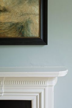 a painting hanging on the wall above a fireplace