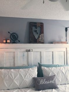 a bed with white sheets and pillows in a bedroom next to a wall mounted clock