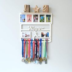 a wall mounted medal rack holds medals and other sports related items, with the word winner written on it