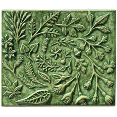 a green tile with leaves and flowers on it