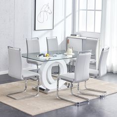 a glass dining table with white chairs and a rug on the floor in front of it