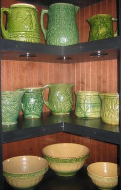 many green and yellow dishes are on shelves