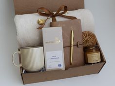 a gift box containing a mug, candle, and other items for someone's special occasion