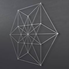 an abstract sculpture made out of white wire on a gray background with the shape of a diamond