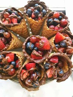 several cones filled with fruit and chocolate on top of a table