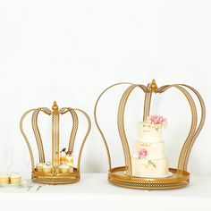 two gold crowns with flowers on them sitting next to each other, one is white and the other is pink