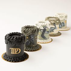 three cakes with different designs on them sitting side by side in the shape of hats