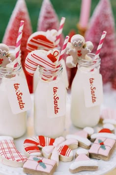 decorated cookies and candy in glass jars on a table