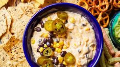 a blue bowl filled with black beans, corn and jalapenos surrounded by chips