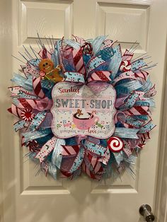 a wreath on the front door with candy canes and candies hanging from it