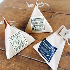 three paper cones with labels on them sitting on a wooden table