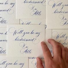 a person's hand on top of some blue calligraphy