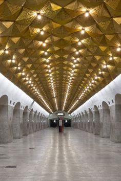 an empty subway station with many lights on the ceiling and no people walking in it