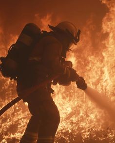 a firefighter using a hose to extinguish the flames