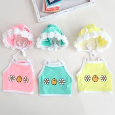 four baby bibs with flowers on them and one is pink, green, yellow, blue