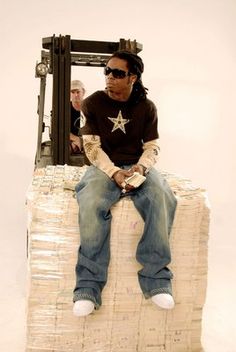 a man sitting on top of a stack of cardboard boxes with his feet propped up