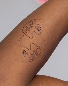 a woman's leg with two faces drawn on it