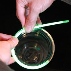 a person holding a lit up glass in their hand