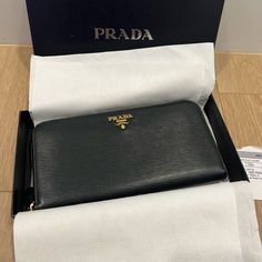 Prada Zip-Around Saffiano Leather Wallet Portafoglio Lampo (Black/Gold). Condition Is Pre-Owned. Used Only Once To A Trip And Then Stored In The Closet Since Then. Used In A Great Condition, Some Minor Leather Scuff As You Can See From The Pictures Other Than That Excellent Used Condition. Retail Price $750 Prada - Black Signature Saffiano Leather With Gold Hardware. Zip-Around Wallet. Interior Zip Pocket. Eight Credit Card Slots. Two Billfold Pockets. Interior Zip Change Pockets Made In Italy Size: 4.24"H X 7.5"W X 0.75"D Weighs Approximately 7 Oz. Luxury Saffiano Leather Wallets For Everyday Use, Luxury Saffiano Leather Wallet, Designer Black Saffiano Leather Wallets, Black Saffiano Leather Wallet For Everyday Use, Bags Prada, Prada Bags, In The Closet, The Closet, Prada Bag