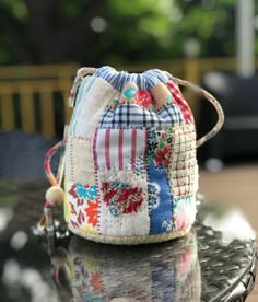 a small purse sitting on top of a table next to a glass tablecloth covered bench