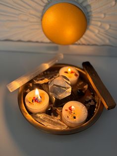 some candles are sitting in a bowl on a table