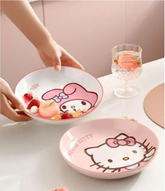 two bowls with hello kitty designs on them, one has strawberries and the other has strawberrys