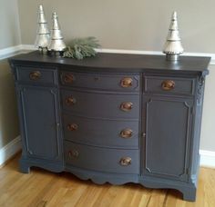 an old dresser with two silver bells on top